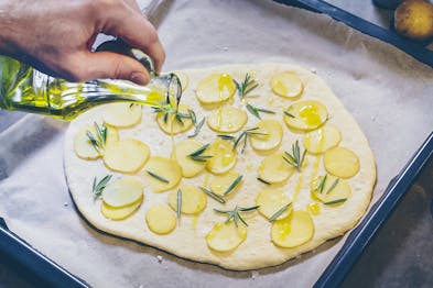 Kartoffel-Focaccia mit Olivenöl beträufeln