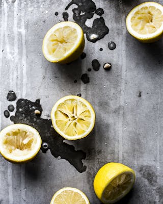 Zitronenhälften liegen aufgeschnitten auf einem grauen Untergrund