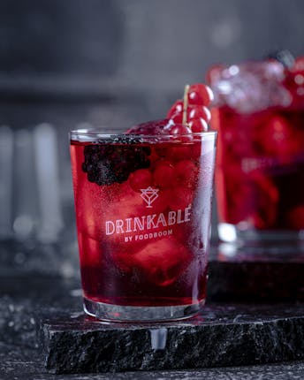 Zwei Gläser mit einem roten Drink und verschiedenen Beeren darin