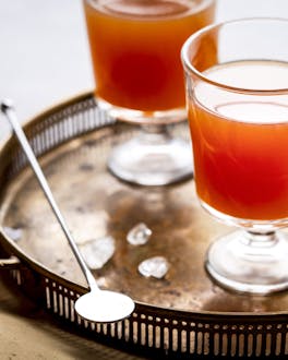 Brown Derby Cocktail mit Grapefruit und Whiskey auf einem Silbertablett.
