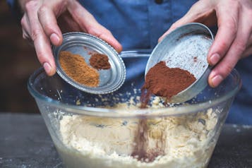 Kakaopulver und Gewürze werden zu aufgeschlagener Margarine in einer großen Glasschüssel gegeben