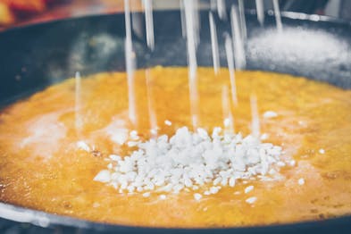 Reis wird in die Sauce für Pomodori ripiene gegeben