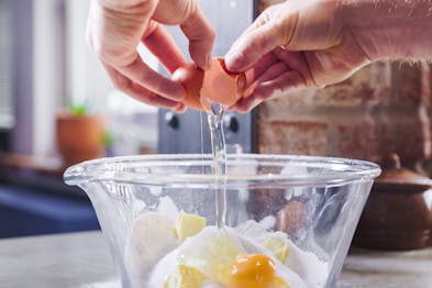 Eier werden zu Zutaten für den Teig für Chiacchiere gegeben